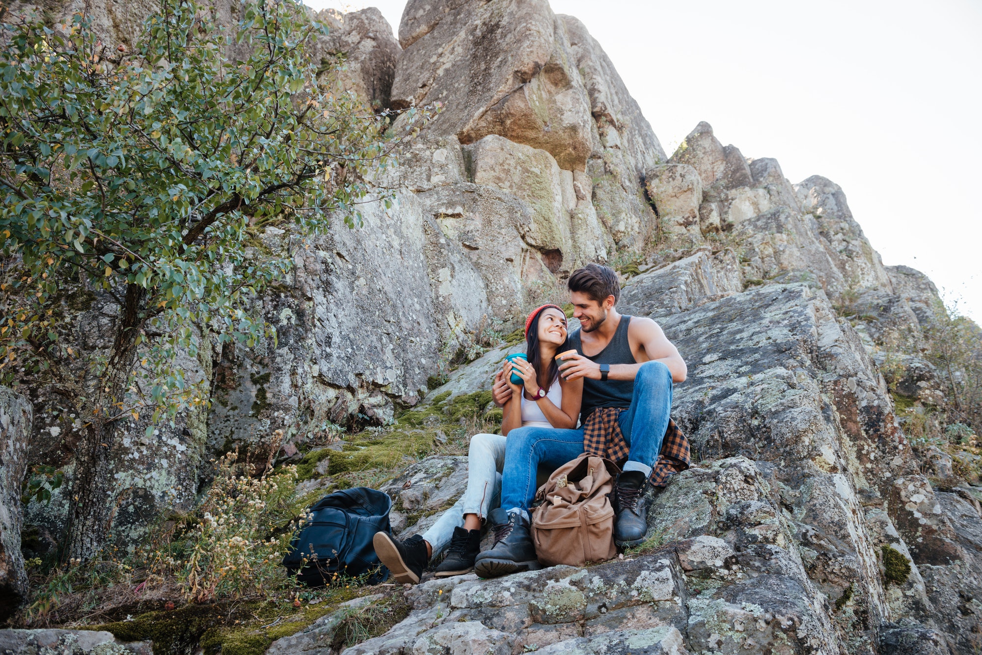 Portrait of a happy couple resting while hiking in mountains