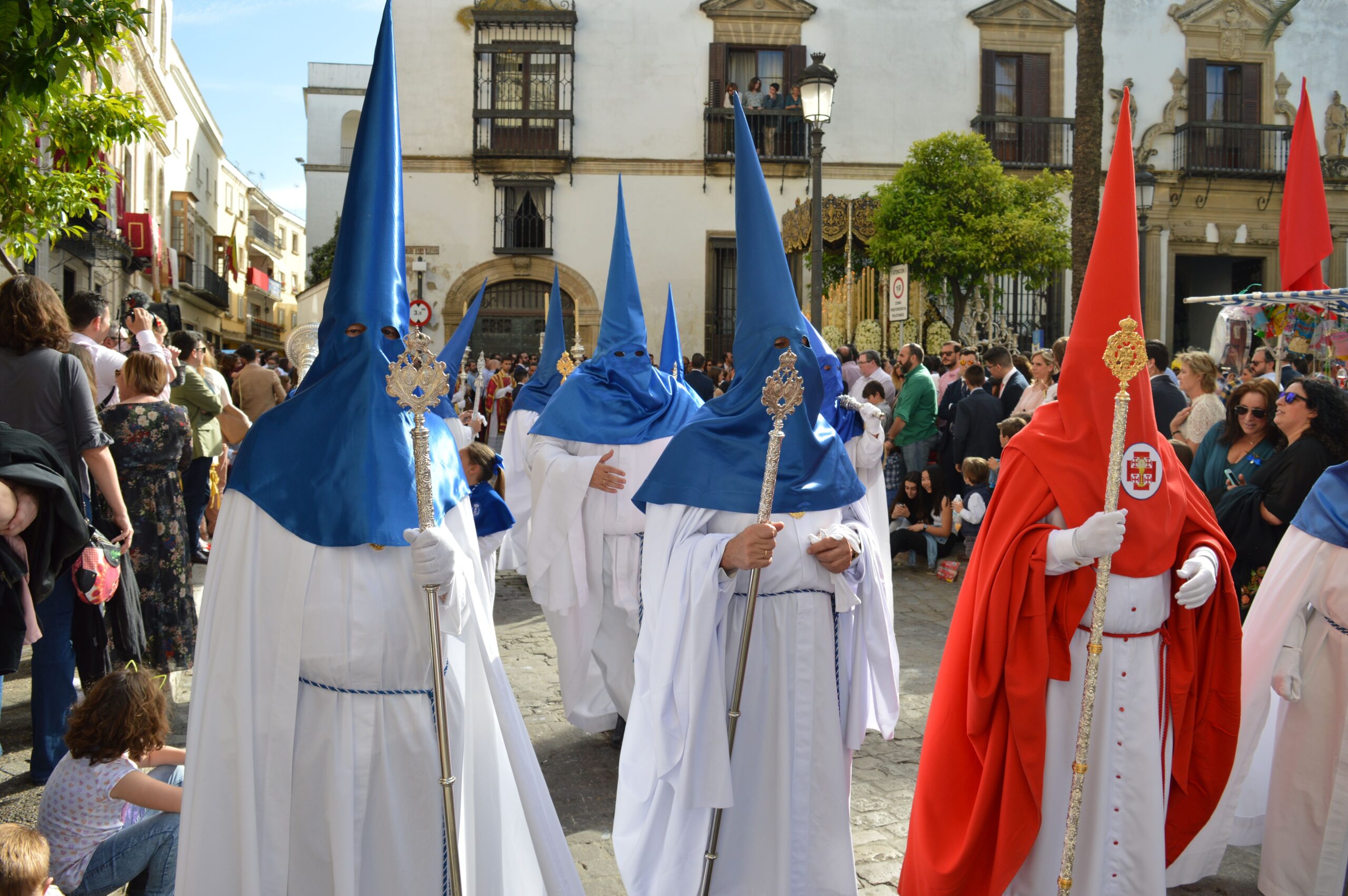 Colorful traditional procession with participants in robes and hoods in Seville, Spain.